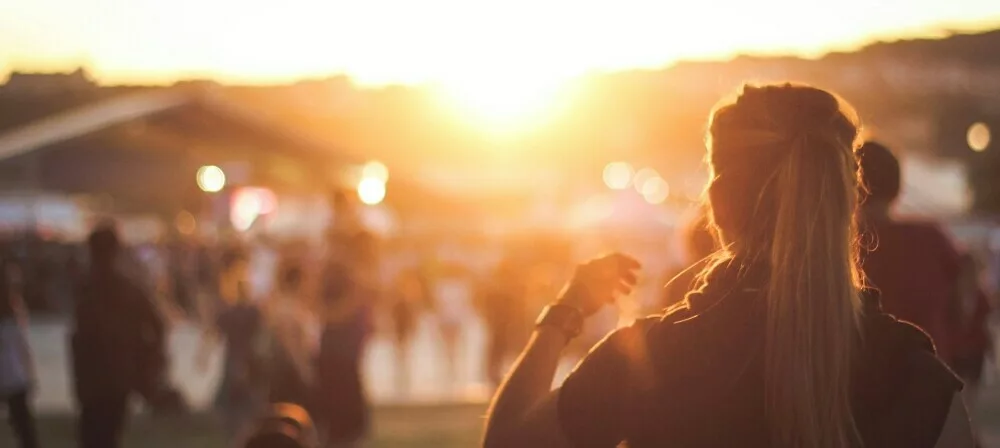 photo of a girl seen from the back in a festival during sunset