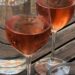 Grenache Noir Grape In Provence - two glasses of rosé with a bottle of water on a wooden table