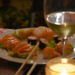 a plate with sushi and a glass of white wine