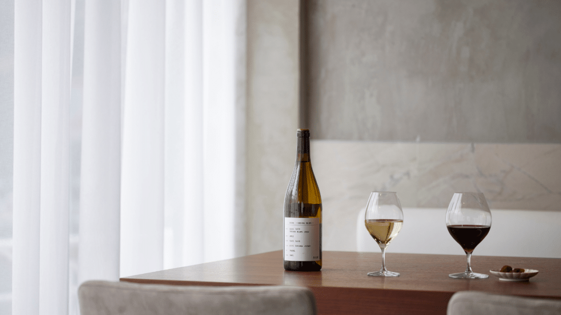 une bouteille de vin japonais avec un verre de vin blanc et un verre de vin rouge